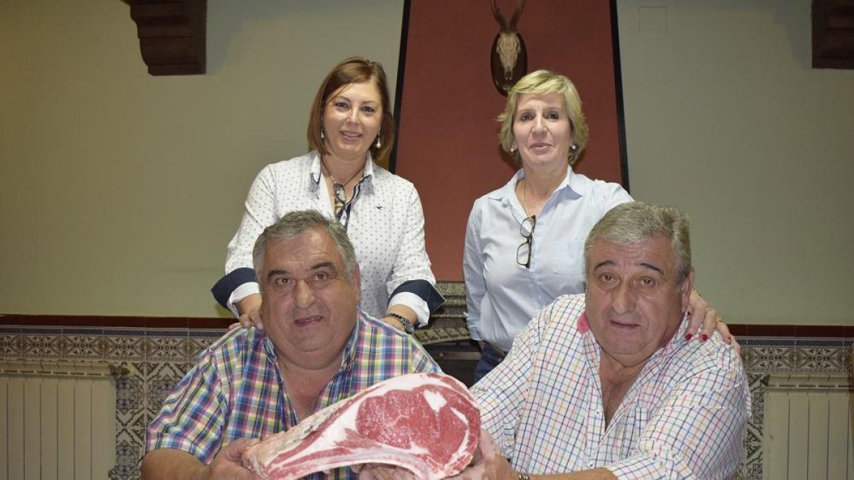 Los hermanos Carlos y José Antonio Martín junto a Maribel Redondo y María Díaz con una chuleta de carne de avileña de su propia ganadería en la venta familiar.-ARGICOMUNICACIÓN