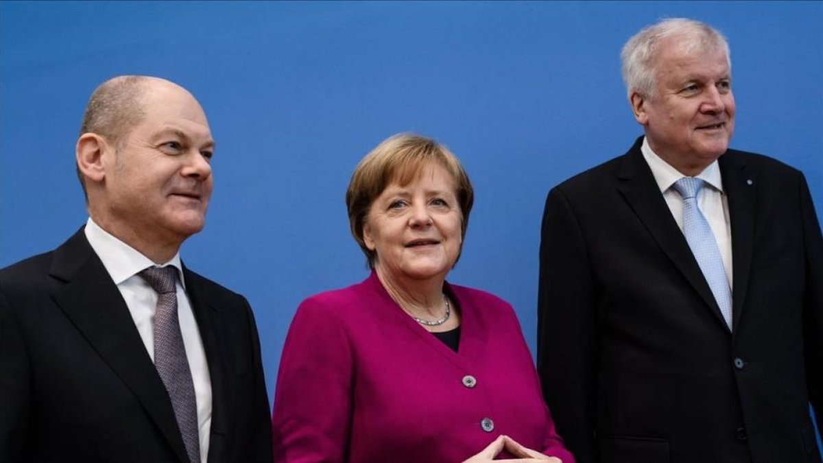 De derecha a izquierda, el líder del Partido Socialdemocrata, Horst Seehofer, la cancillera alemana, Angela Merkel y el líder de la Unión Socialcristiana, Olaf Zcholz.-/ EFE / CLEMENS BILAN