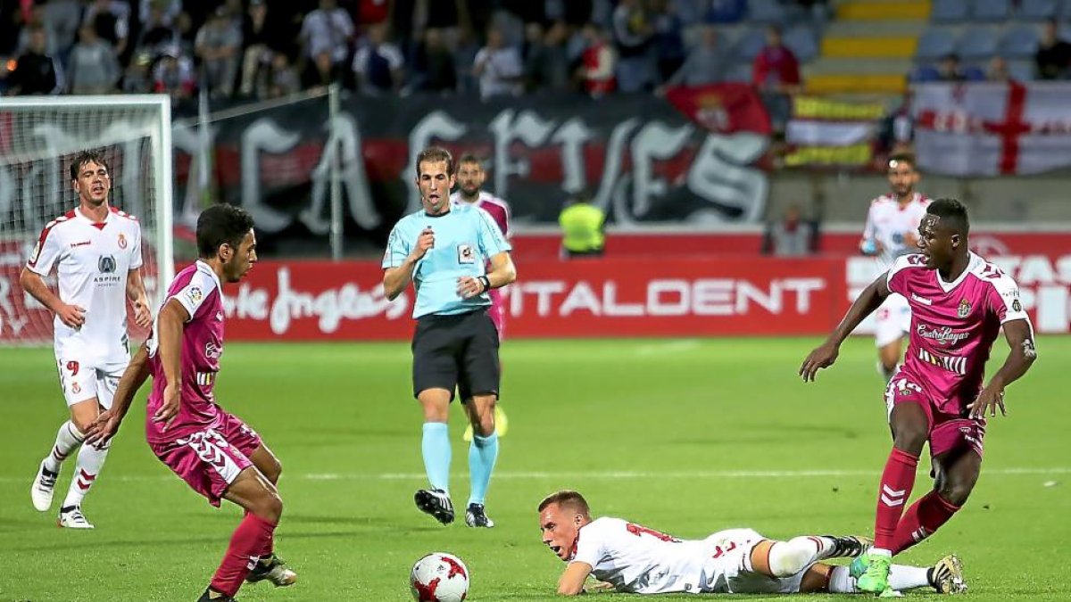 Anuar, autor del tercer gol, se dispone a recibir el balón mientras Yelko observa la jugada desde el suelo, anoche, en el Reino de León.-RAMIRO / DIARIO DE LEÓN