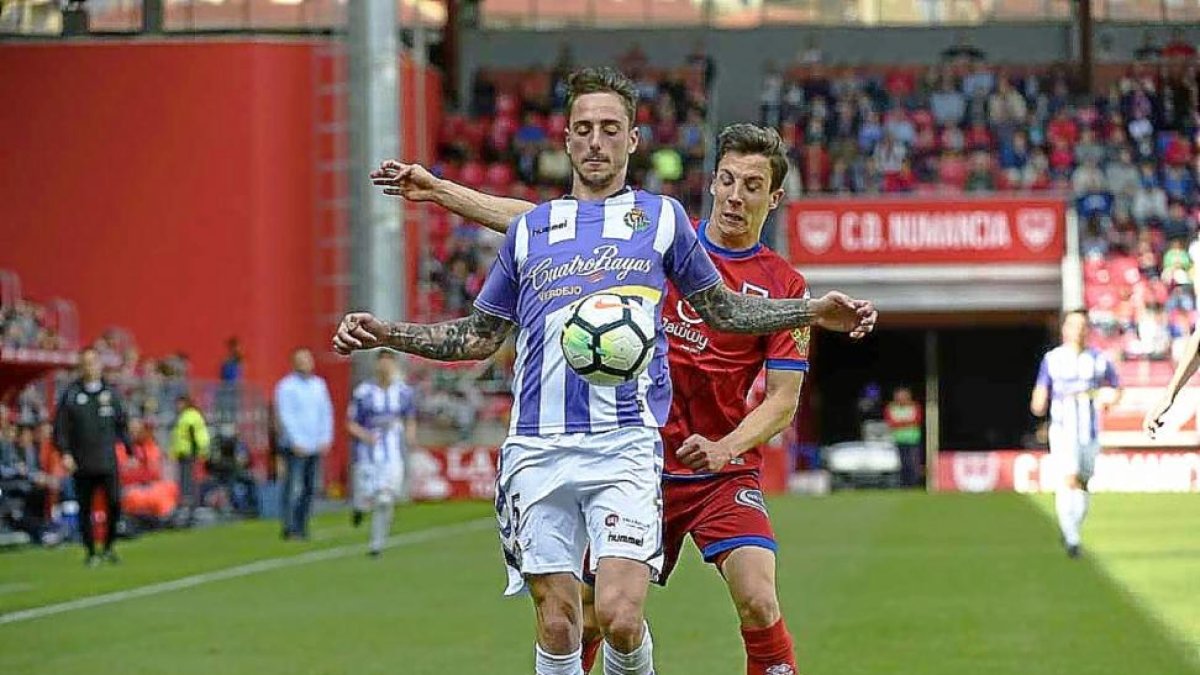 El central blanquivioleta Calero controla el balón ante el atacante numantino Guillermo.-VALENTÍN GUISANDE