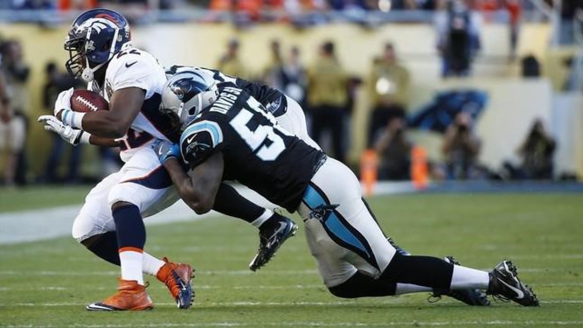 El running back de los Broncos J. Anderson, interceptado por Thomas Davis de los Carolina Panthers.-