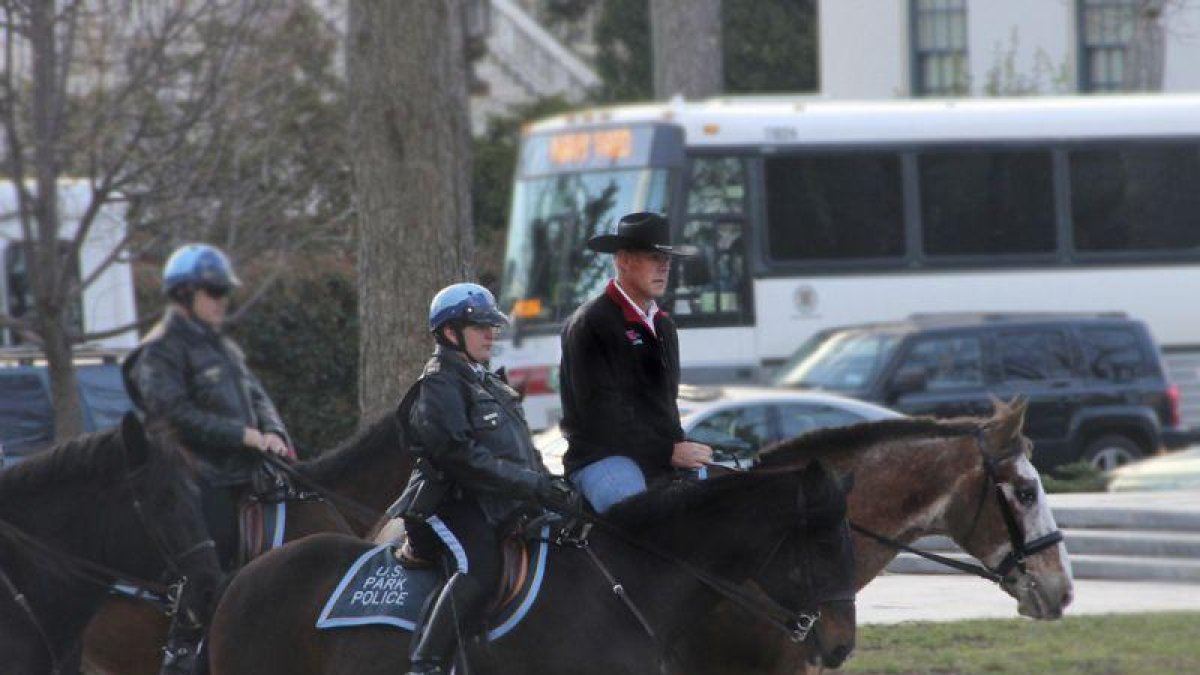 Ryan Zinke, a lomos de un cabllo y con sombrero vaquero, dirigiéndose a la oficina, ayer.-AP