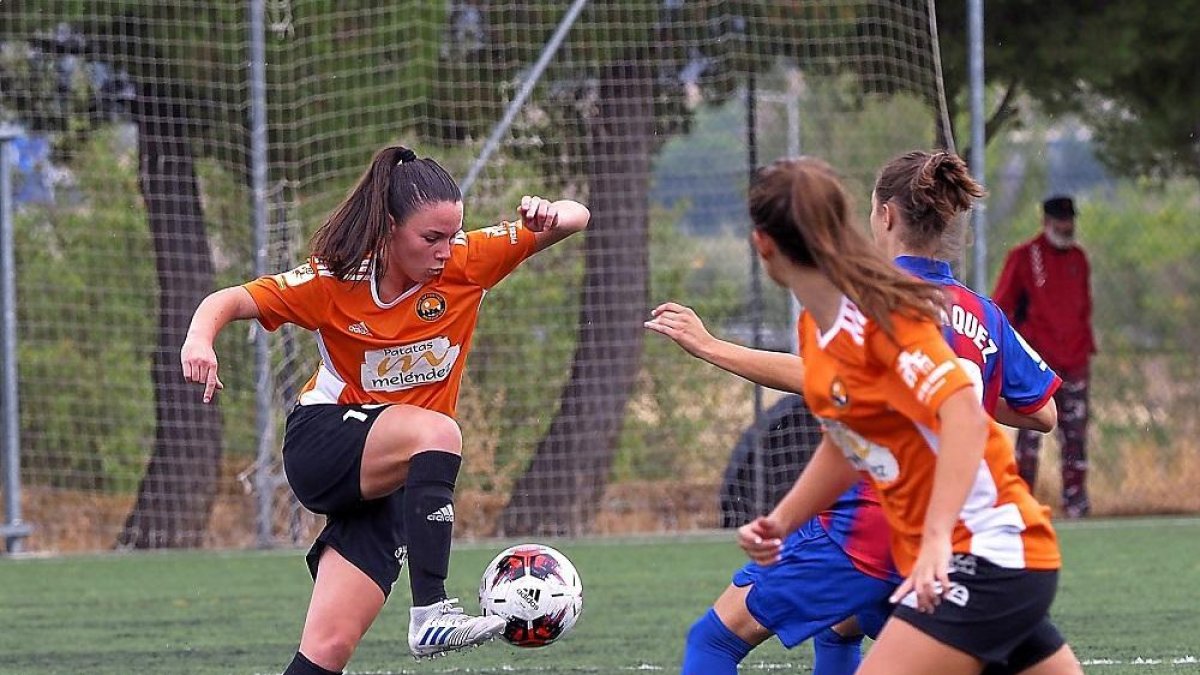 Marta Charle controla el balón e intenta regatear a la jugadora del Eibar.-MIGUEL ÁNGEL SANTOS