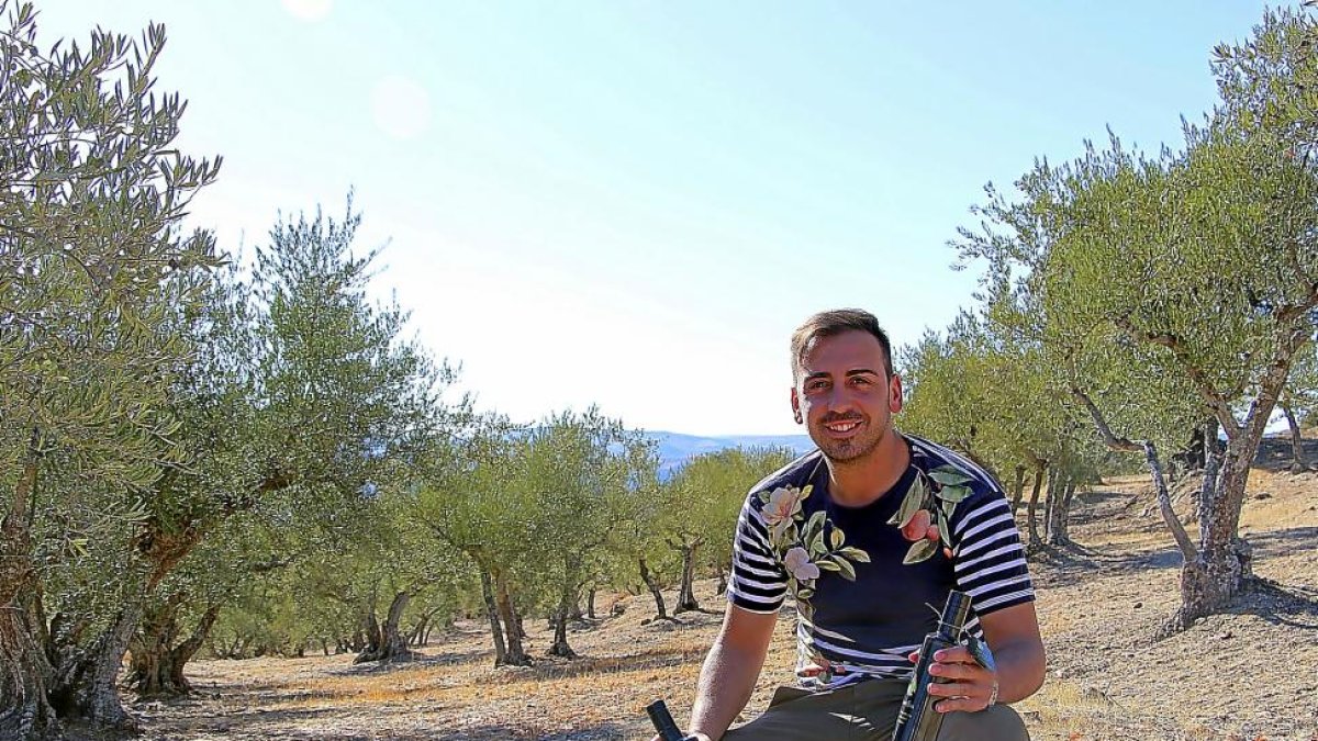 Alberto Díez Ramos, con dos botellas de aceite, en el olivar.-J.L.C.