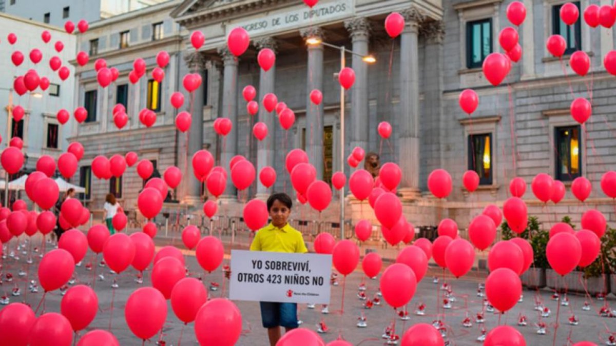 El pequeño Said, de 8 años, sostiene frente al Congreso el cartel en recuerdo de los 423 niños que se han ahogado en el Mediterráneo en el último año.-Pedro Armestre/Save the Children