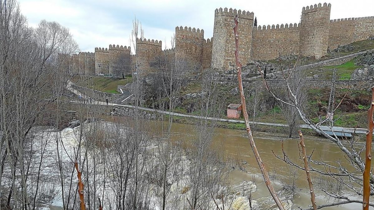 Crecida del río Adaja a su paso por la capital abulense, con las murallas al fondo.-A. GARCÍA