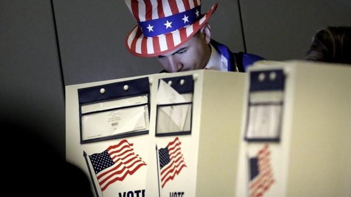 Un hombre vestido como el Tio Sam ejerce su derecho al voto en un centro electoral en el eastside de Nueva York en las eleccines presidenciales del 2016.-EFE / PETER FOLEY