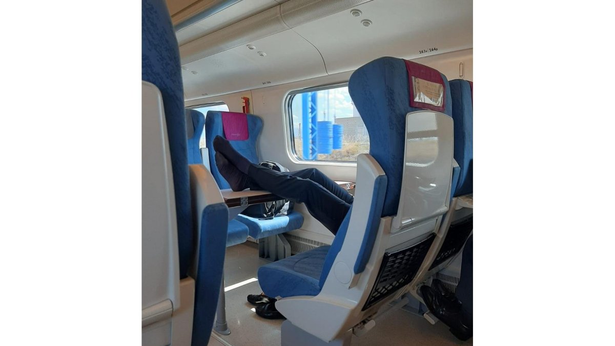 Un hombre sin zapatos pone los pies sobre la mesa en un tren de Renfe. - @AVE_Valladolid