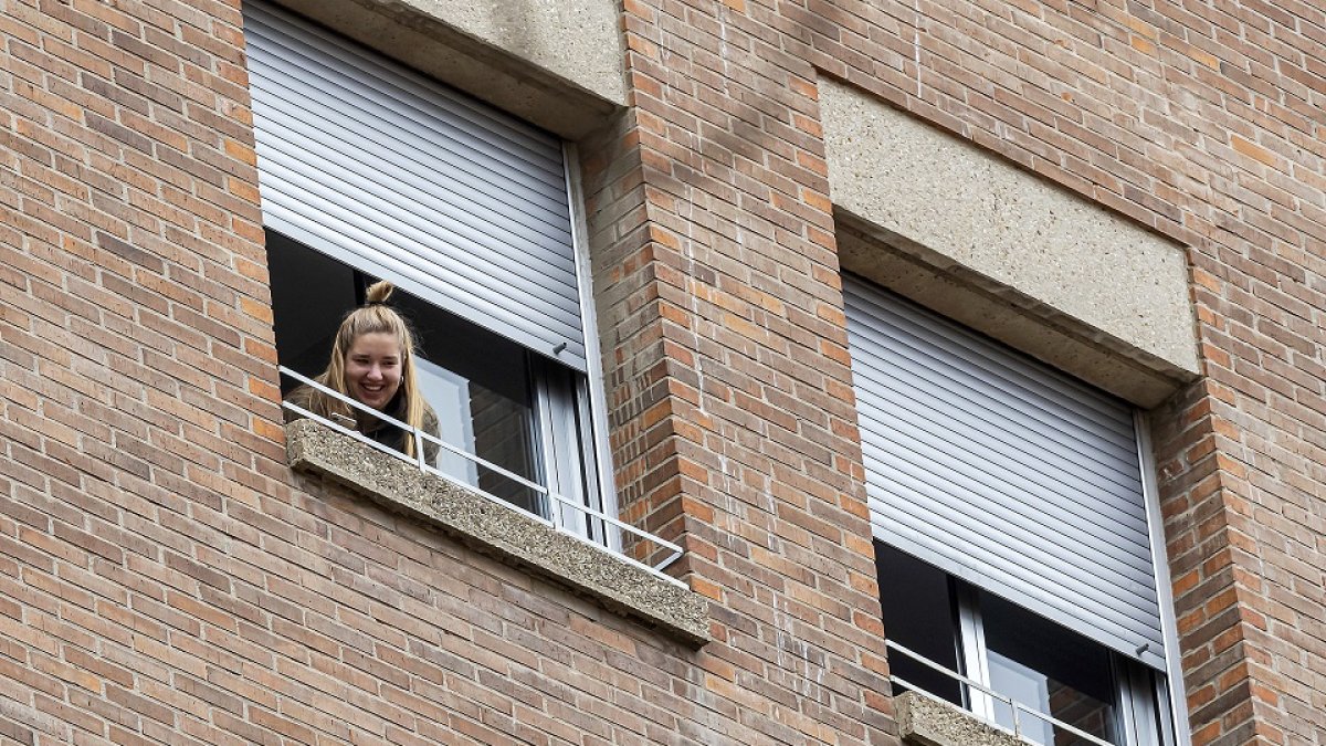 Usuaria de la Residencia Universitaria Alfonso VIII se asoma a la ventana de su cuarto durante el confinamiento del centro . PABLO REQUEJO / PHOTOGENIC.