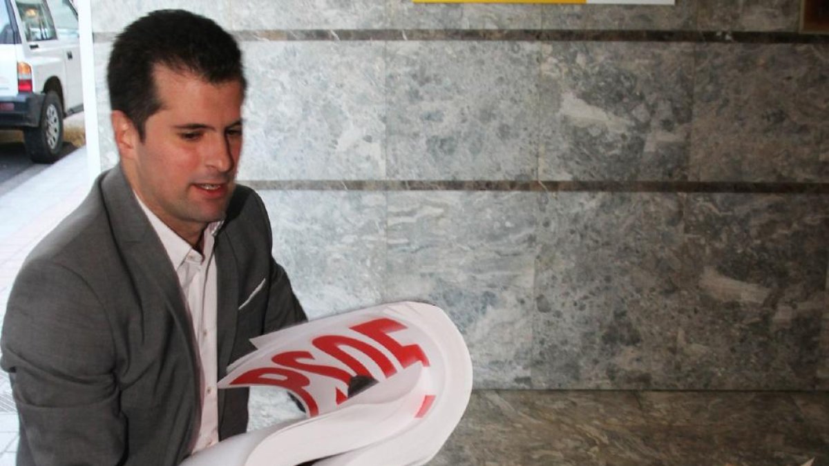 El secretario general del PSOE de Castilla y León, Luis Tudanca, con un mazo de carteles electorales antes de la presentación de los candidatos del PSOE al Congreso y al Senado por Palencia.-ICAL