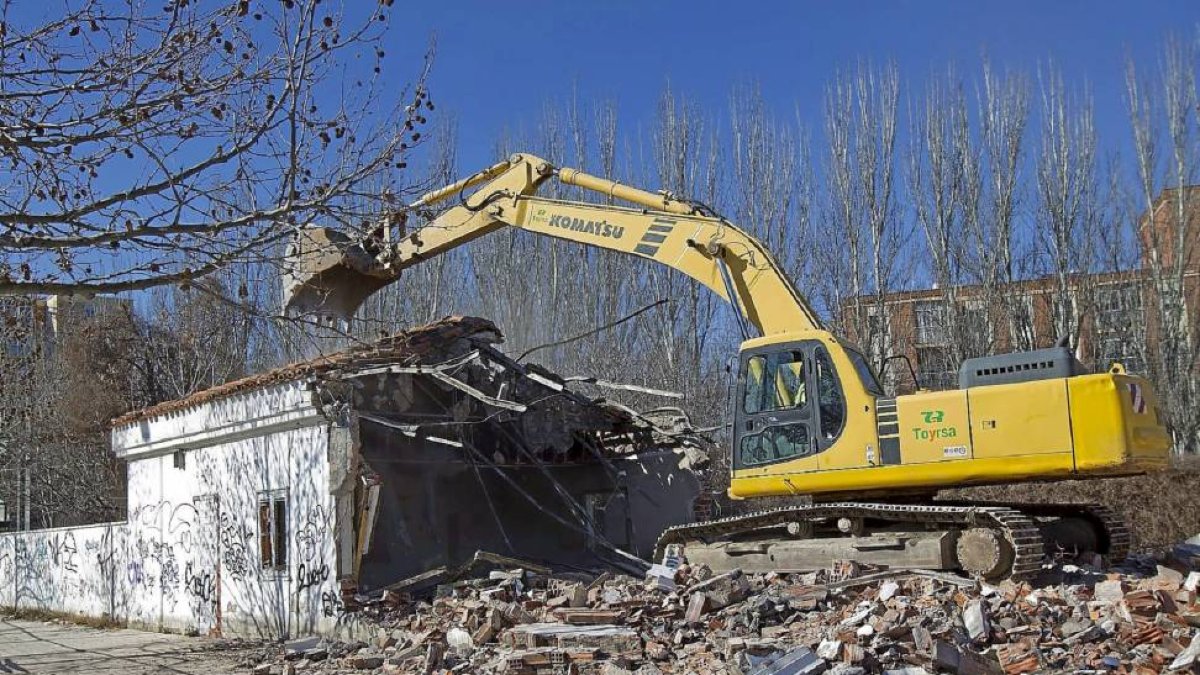 La máquina derriba una de las naves que servía de albergue para personas sin hogar en el parque de Las Norias-J.M.Lostau