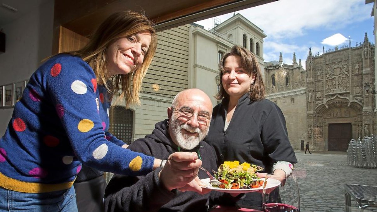 Manuel Sierra sentado entre Natalia Burguillo (i) y Sara Grande (d) se dispone a probar una ensalada con San Gregorio como telón de fondo.-M. A. SANTOS