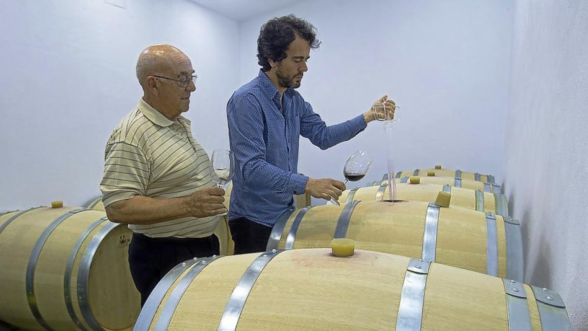 Fernando Galindo y su padre Fidencio prueban el vino de una barrica.-J.L.C.