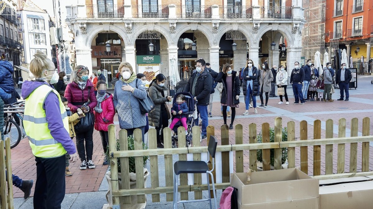 Varias personas forman cola respetando las medidas de seguridad en la Plaza Mayor para entrar al tren navideño. REPORTAJE GRÁFICO:J.M. LOSTAU