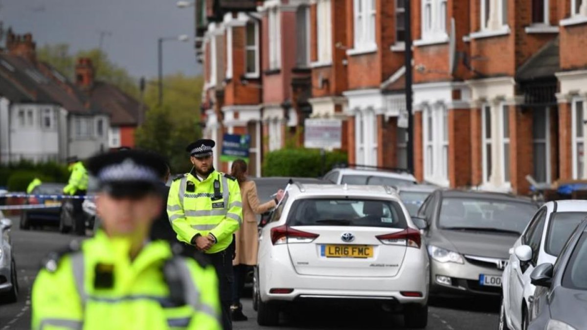 Agentes británicos mantiene un cordón policial en la calle residencial del noroeste de Londres donde tuvo lugar el tiroteo durante una operación antiterrorista, el 28 de abril, en Londres.-BEN STANSALL