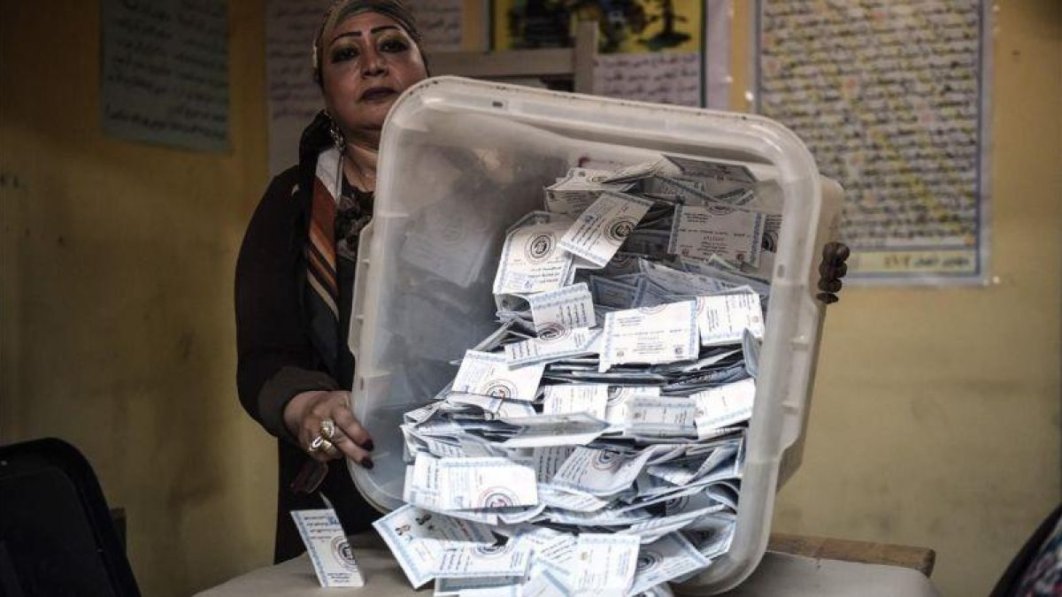 Una miembro de una mesa electoral muestra las papeletas depositadas en una urna en El Cairo.-AFP / MOHAMED EL-SHAHED