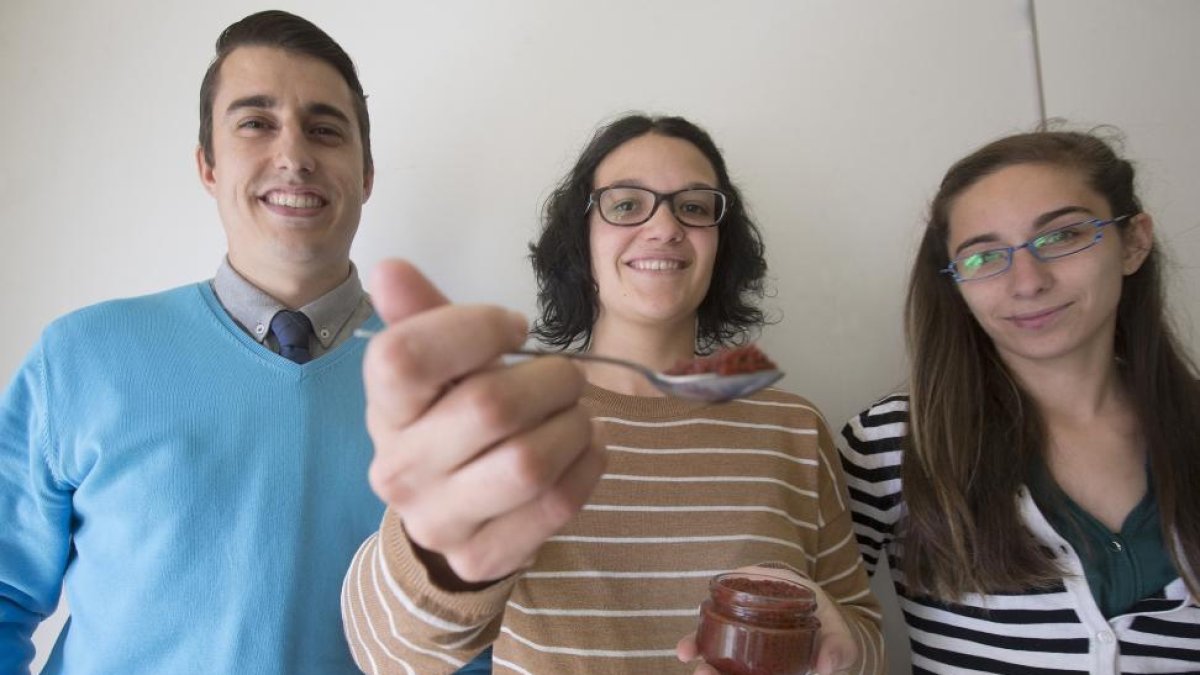 César Bataner, Laura Herrero y Sandra Rodríguez con una tarro que contiene las esferificaciones de jamón ibérico creado por ellos mismos.-RAÚL OCHOA