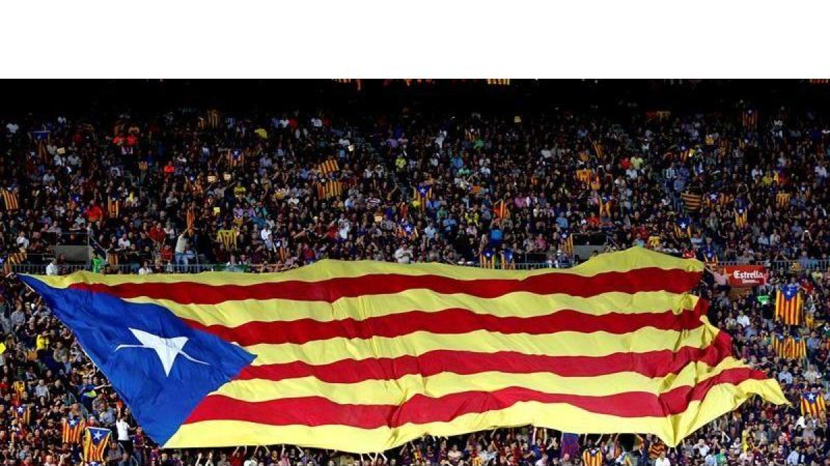 Aficionados del Barcelona despliegan una bandera 