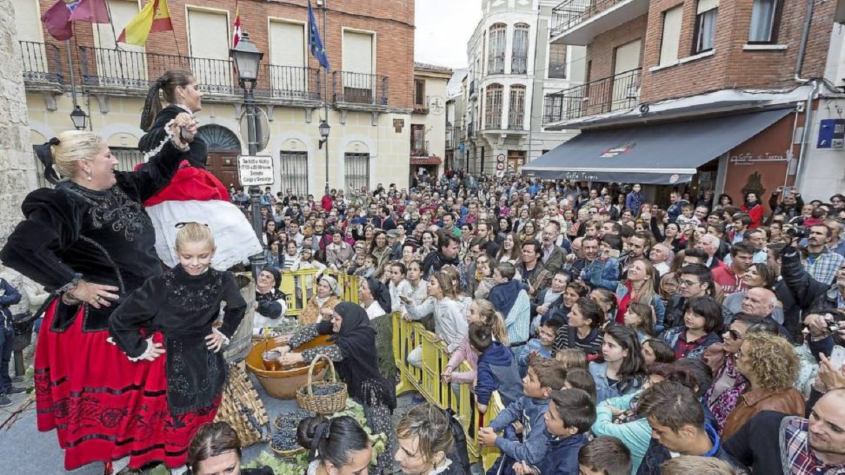 El público abarrota la Plaza de España la espera de probar el primer mosto, mientras Carmen pisa la uva sobre el escenario al ritmo de la música.-Miguel Ángel Santos