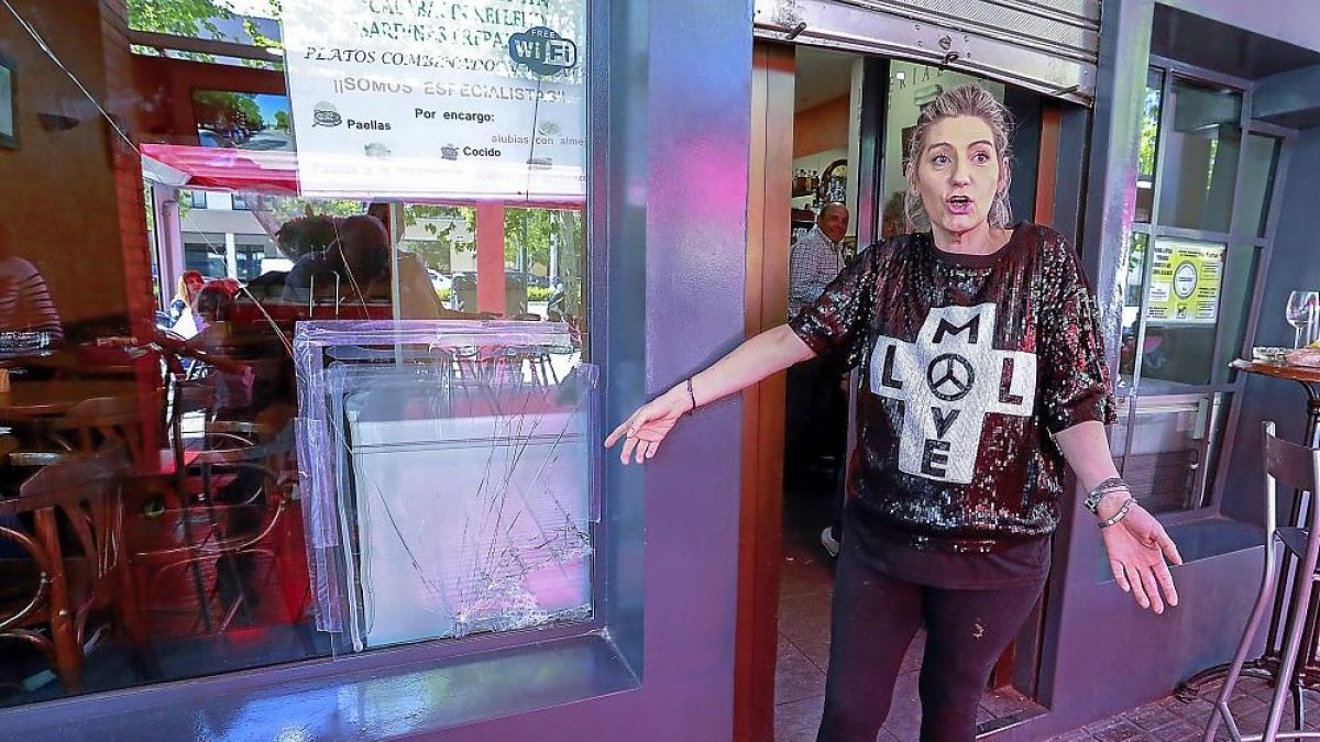 Beatriz, una de las dueñas del bar Imperial de Parque Alameda, muestra la luna rota del bar tras el robo.-J.M. LOSTAU