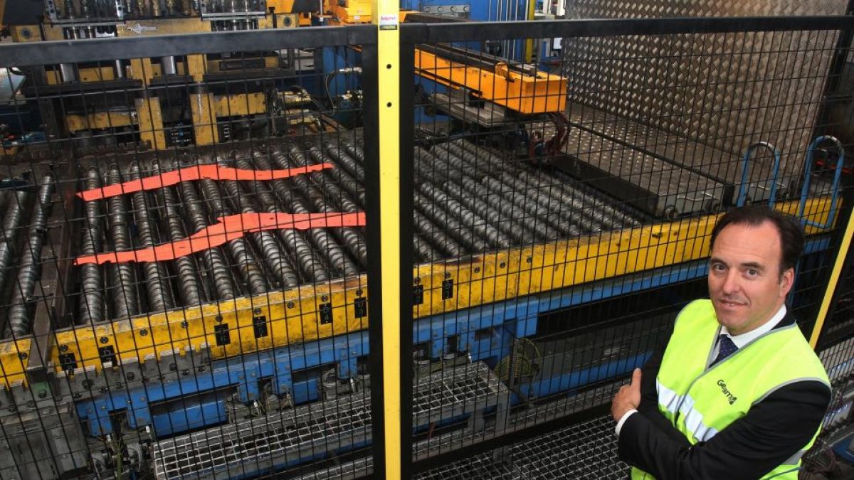Miguel Paniagua, director de la fábrica de Gestamp en Palencia posa ante la maquina de estampación en caliente en el momento de salir una pieza a 900 grados.-MANUEL BRÁGIMO
