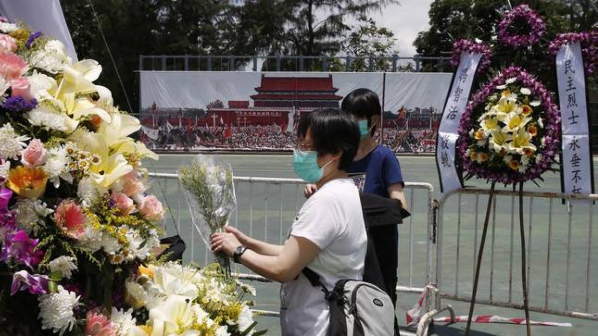 Dos mujeres colocan flores en el memorial a las víctimas de Tiananmen, en Hong Kong.-Foto: Kin Cheung / AP / KIN CHEUNG