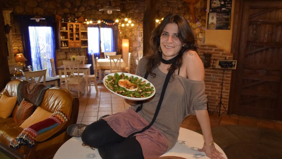 Nayara, en el interior del comedor, con una ensalada del Tiétar con higos y el ‘tayín’ de cordero sobre la mesa.-ARGICOMUNICACIÓN