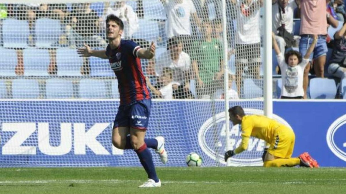 Melero, atacante del Huesca, celebra el único gol del partido mientras Masip se encuentra de rodillas al lado del balón.-LOF