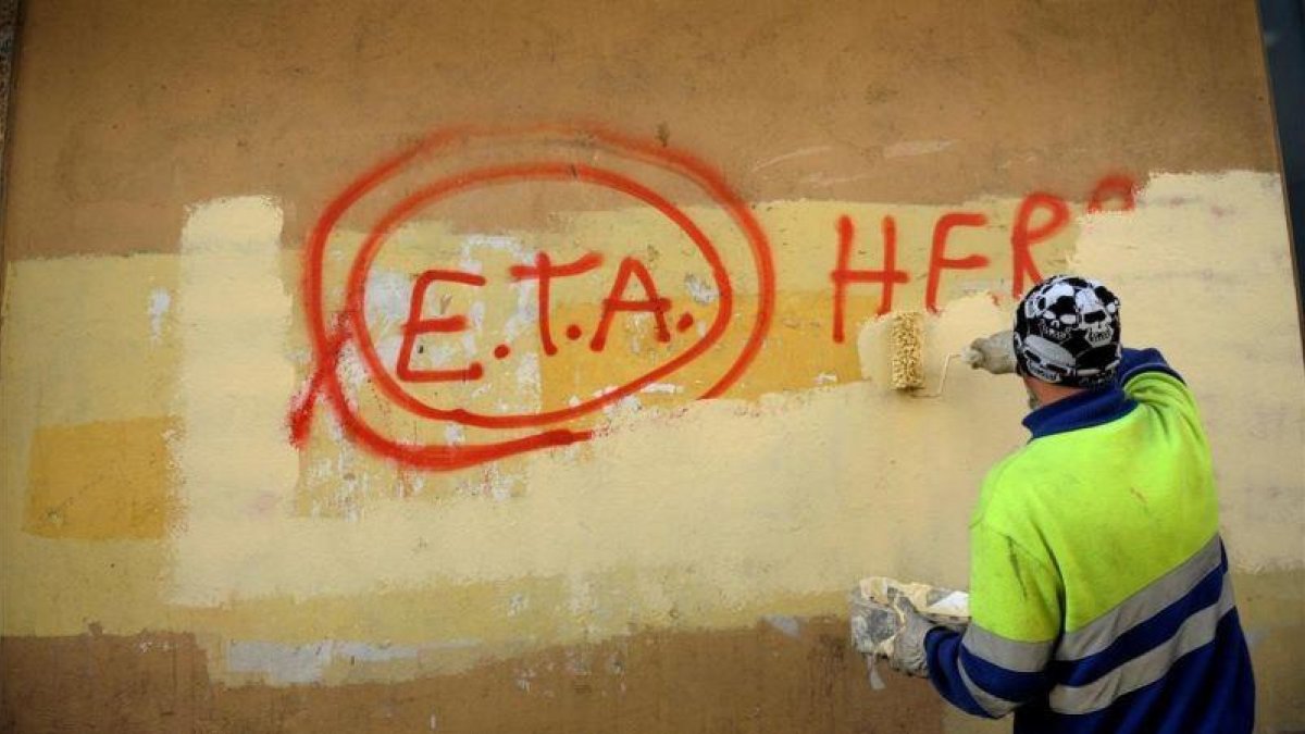 Un operario borra una pintada en la que aún se puede leer ETA, en una imagen de archivo.-REUTERS