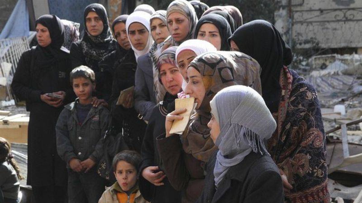 Mujeres de Yarmuk esperan la entrega de ayuda humanitaria.-Foto: HANDOUT / REUTERS
