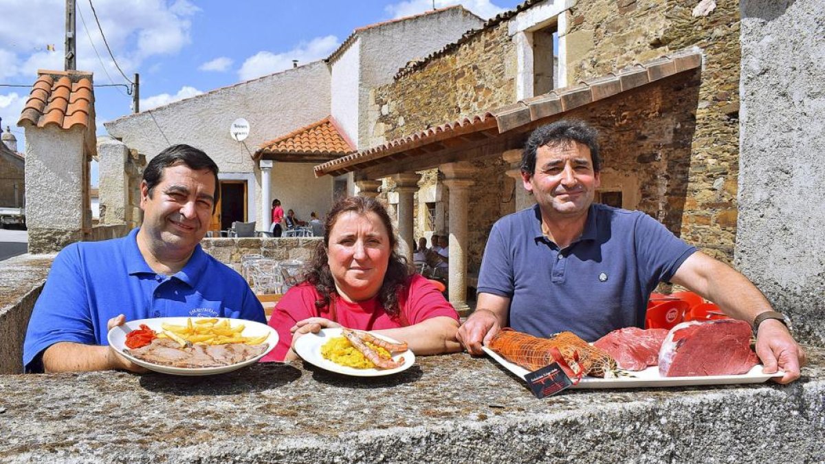 Agustín y Susana, junto a José Manuel Calvo (derecha), el carnicero de Villar de la Yegua, en el patio del centro social y restaurante.-ARGICOMUNICACIÓN