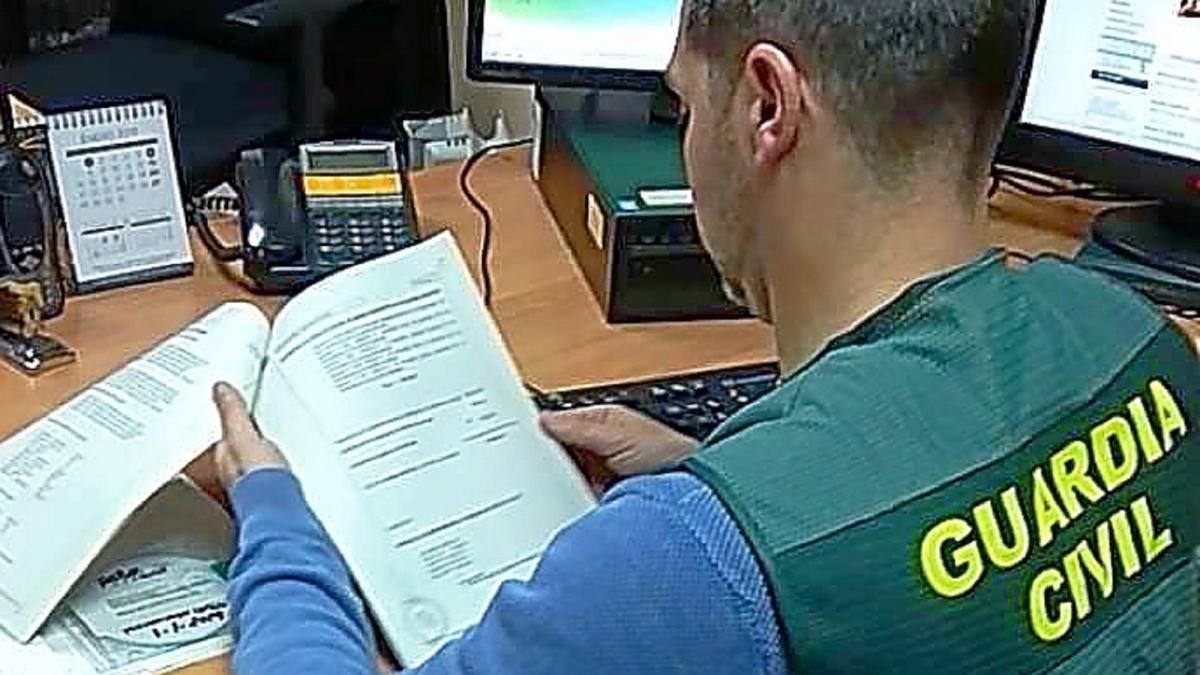 Un guardia civil revisa documentación.-MUNDO