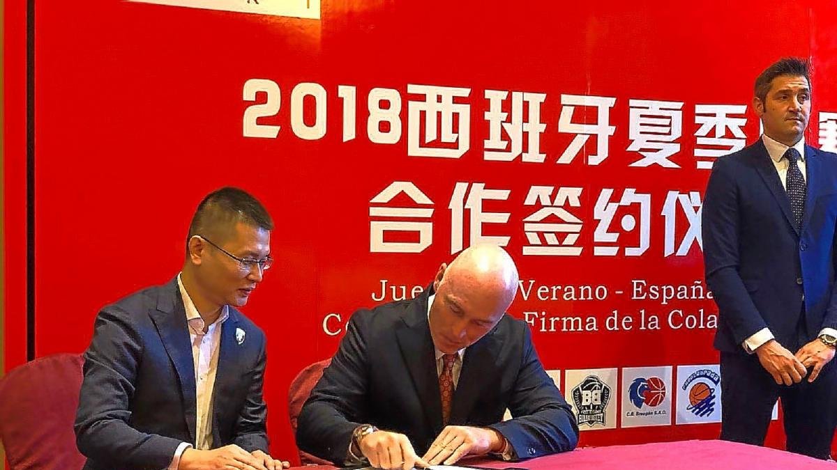 Mike Hansen firma un contrato ante la mirada del director general de los Leopards, Wang Jue.-EL MUNDO