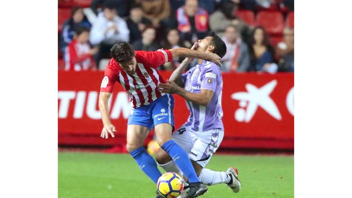 Iban Salvador se queja de un manotazo en el partido frente al Sporting disputado anoche en El Molinón.-LOF