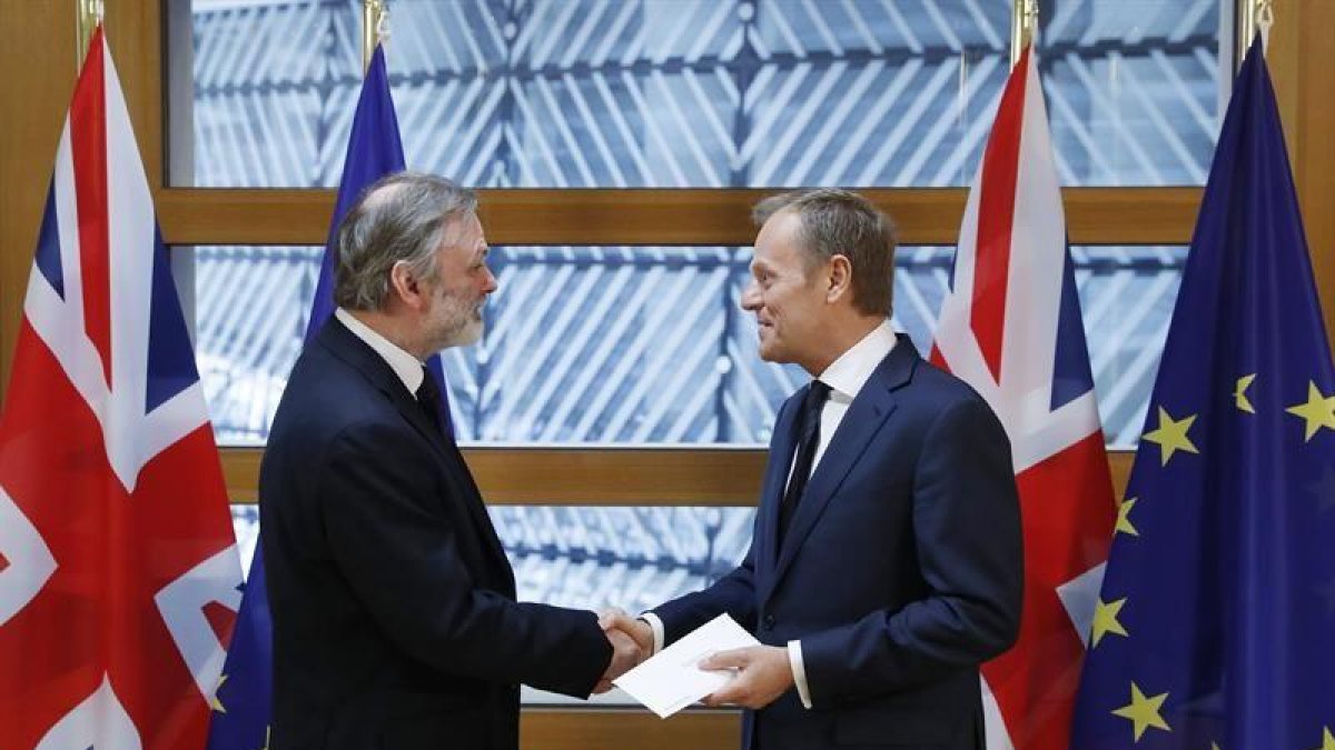 El embajador británico ante la Unión Europea, Tim Barrow (izq), entrega la carta que invoca el artículo 50 del Tratado de Lisboa al presidente del Consejo Europeo, Donald Tusk, en Bruselas.-EFE