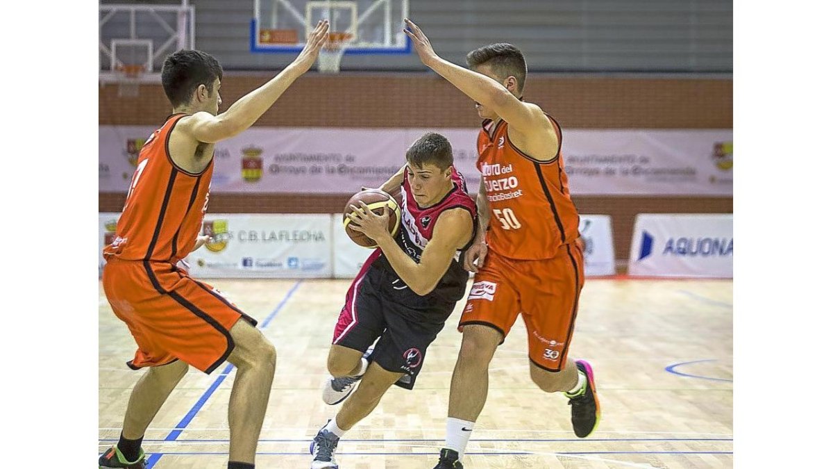 Un jugador del Ciudad de Valladolid intenta esquivar a dos rivales.-J. M. LOSTA