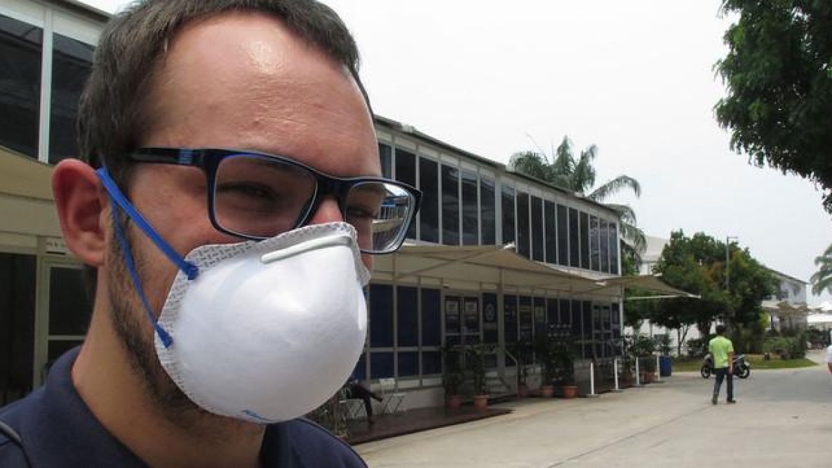 Un trabajador del Dorna, organizadora del Mundial de motociclismo, con una mascarilla para protegerse de la nube tóxica que flota sobre Malasia.-EMILIO PÉREZ DE ROZAS