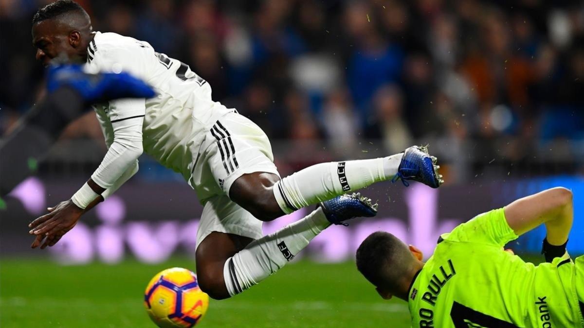 Vinicius cae ante Rulli, este domingo en el Bernabéu.-AFP / GABRIEL BOUYS
