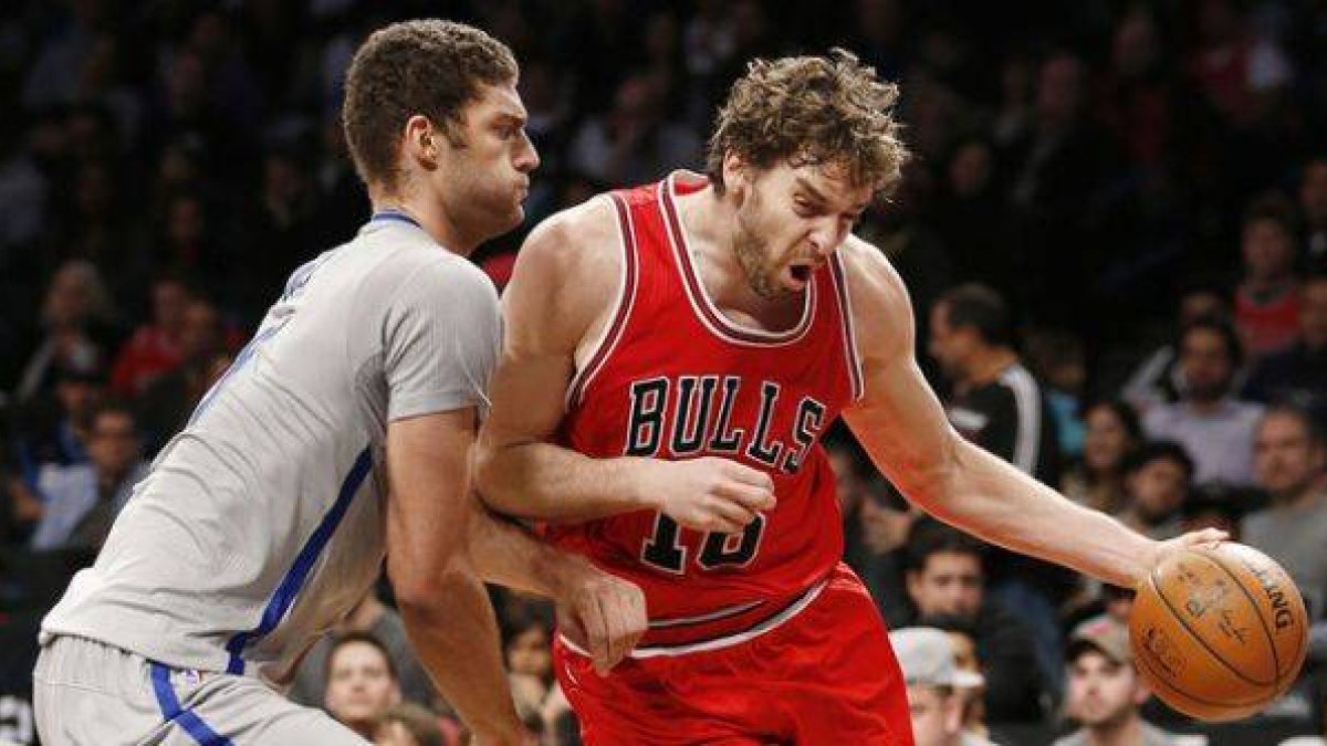 Pau Gasol avanza con el balón ante Brook López, durante el encuentro entre los Bulls y los Nets.-Foto: AP / KATHY WILLENS