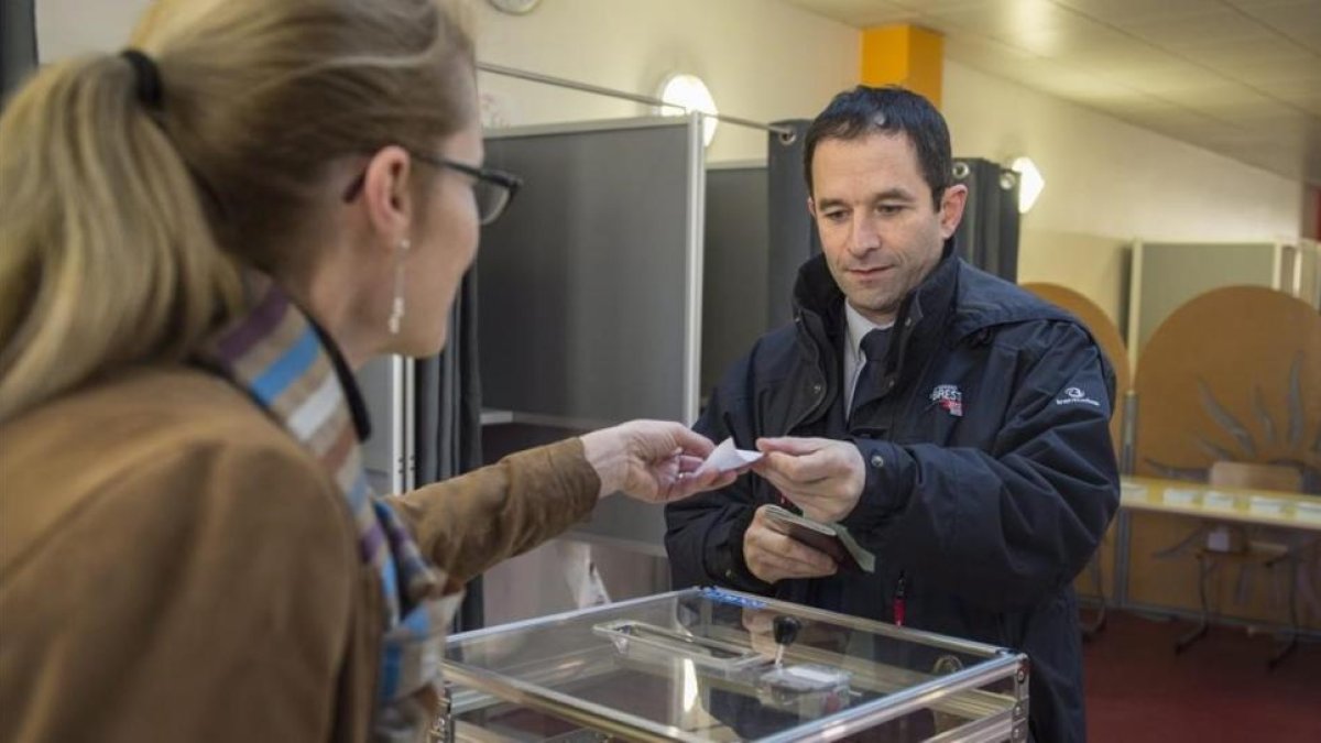 El antiguo ministro de Educación francés Benoit Hamon (derecha), en el momento de votar en las primarias, en París, el 22 de enero.-EFE / JEREMY LEMPIN