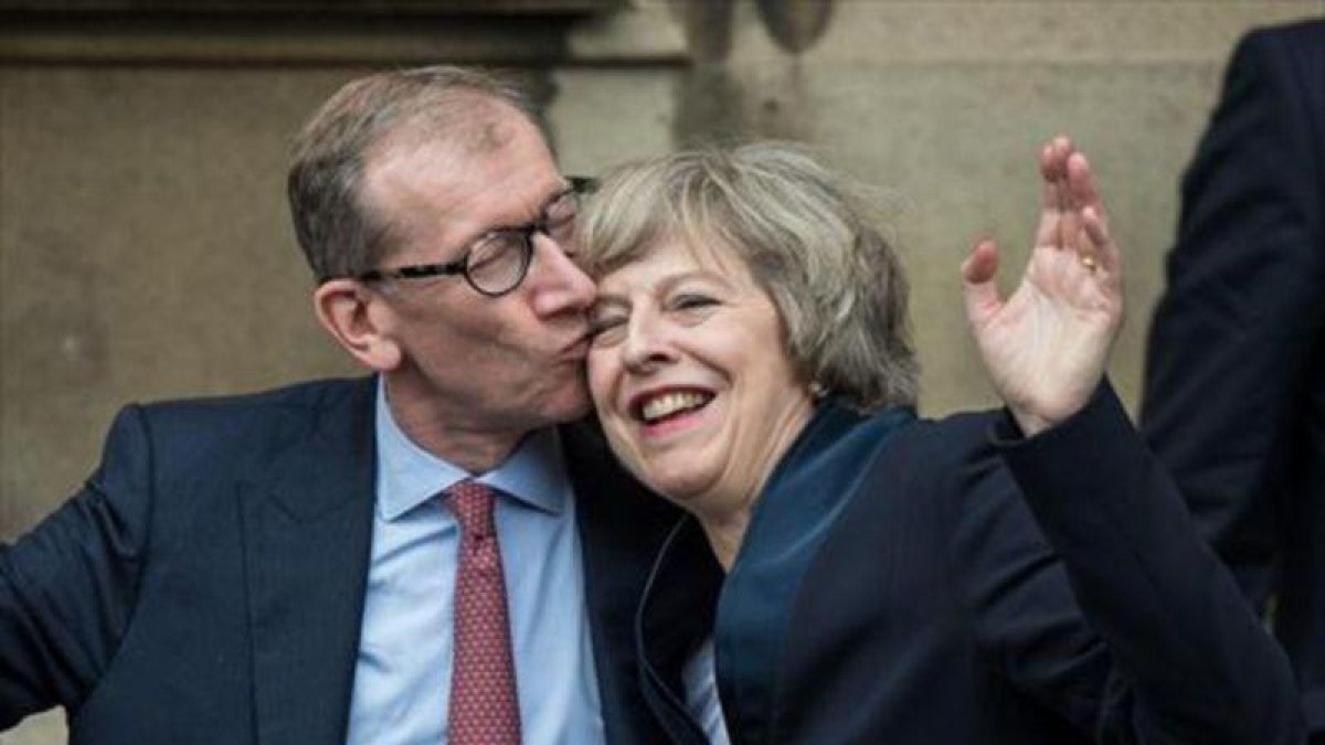 Theresa May recibe un beso de su marido, Philip John May, en el Palacio de Westminster-AFP / CHRIS RATCLIFFE