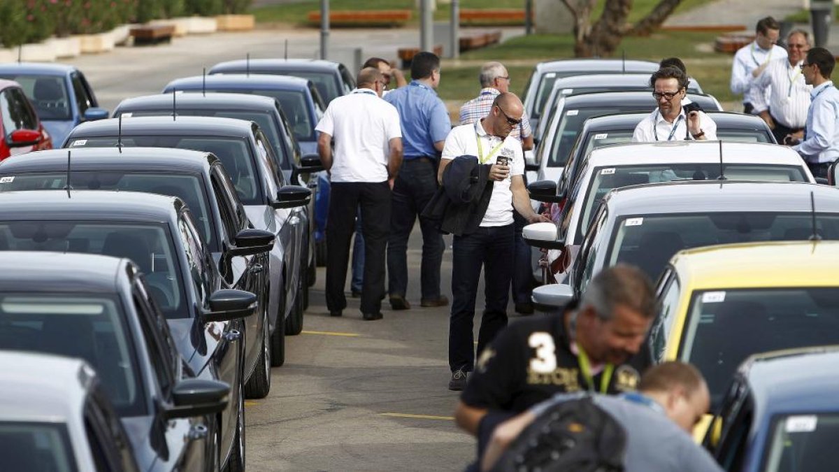 Compradores observando coches.-EL MUNDO