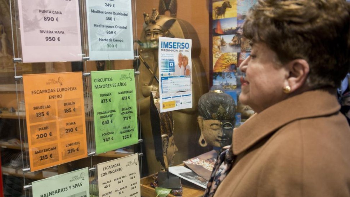 Una mujer consulta las ofertas de viajes organizadas por el Imserso.-EL MUNDO
