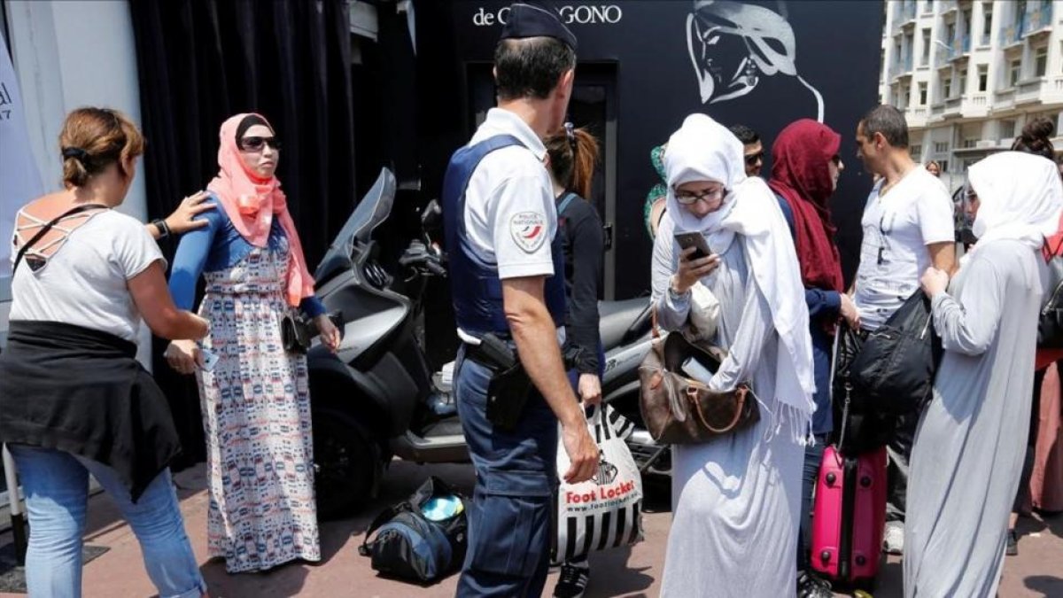 La policía francesa controla a unas mujeres antes del evento organizado en favor del burkini.-REGIS DUVIGNAU