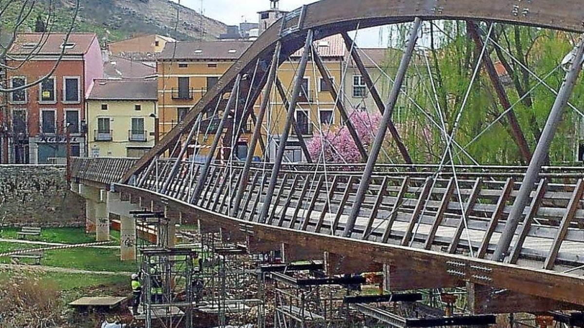Dos operarios comprueban en andamiaje instalado bajo el puente para proceder a los trabajos.-EL MUNDO