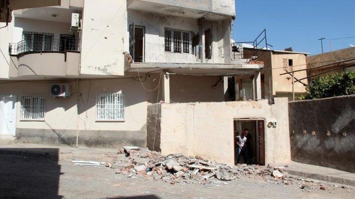 Un vecino limpia escombros en su casa de Nusaybin tras un ataque con morteros desde Siria, el pasado lunes. / ILYA U TOPPER (EFE)-EFE / ILYA U TOPPER
