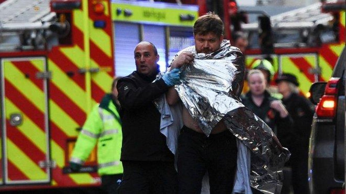 La policía asiste a un hombre herido en el ataque en el Puente de Londres, este viernes.-AFP