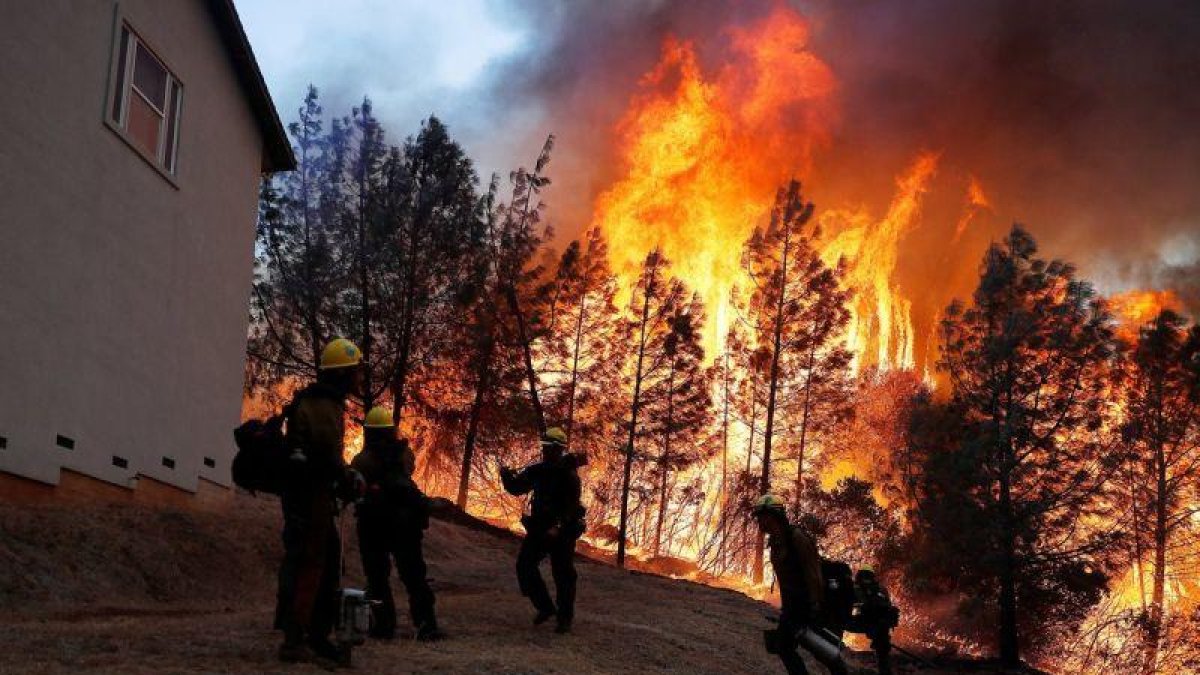 Algunas personas siguen atrapados en la zona afectada por el fuego a la espera de poder ser rescatados por los servicios de emergencia.-EFE