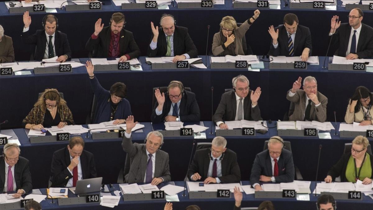 Varios eurodiputados votan a mano alzada en un pleno de la Eurocámara en una foto de archivo-PATRICK SEEGER