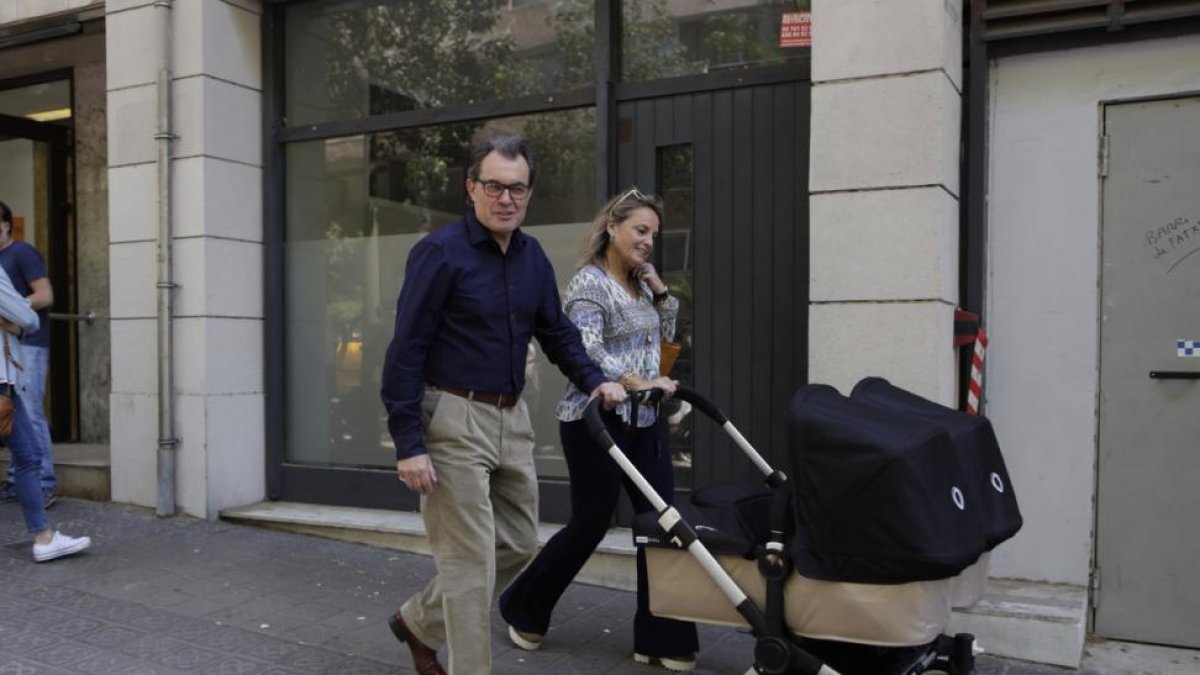 Artur Mas y su esposa, con el carro de sus nietas, tras votar en el 'superdissabte' de CDC.-ALBERT BERTRAN
